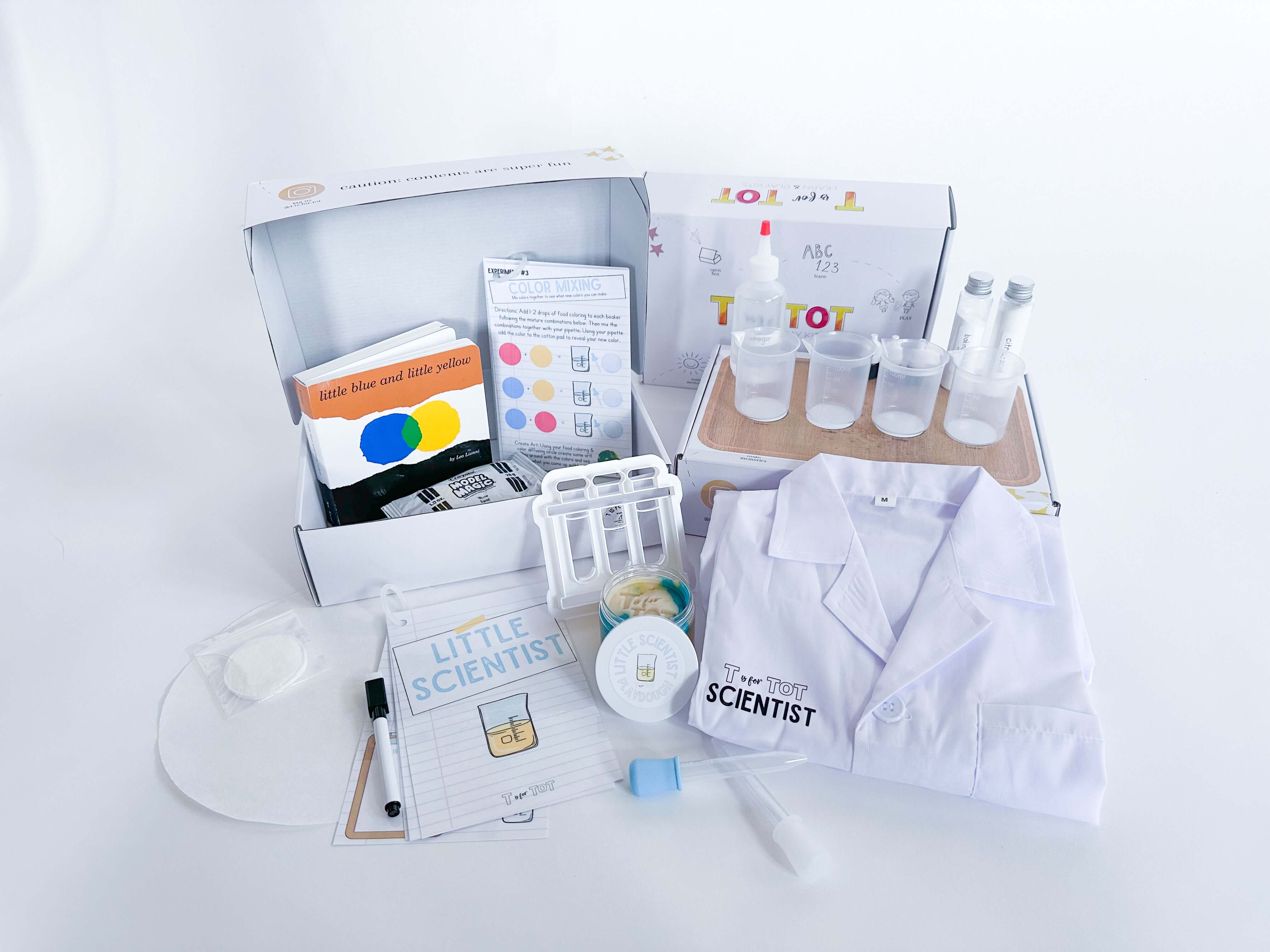 Little Scientist play and learn kit for kids with experiments, beakers, pipettes, food coloring, and other science tools. Includes a lab coat, experiment guide with dry erase marker, and art supplies for creative activities. Comes with